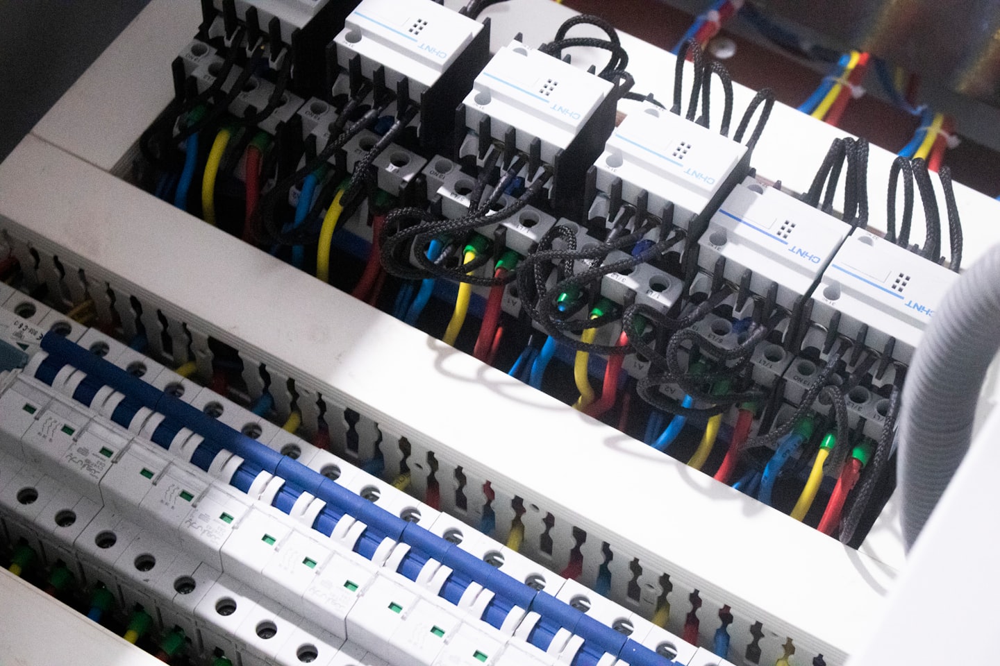 Panel de control eléctrico con interruptores automáticos y cables de colores.